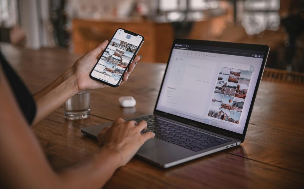 Woman edits social media content on phone and laptop at a cafe in Bali.